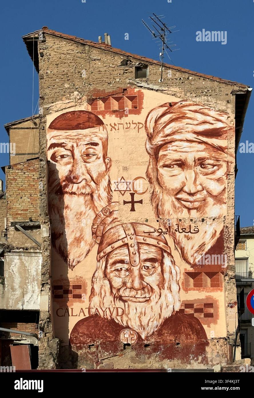 Mural an einer Gebäudemauer in Calatayud, Aragon, Spanien. Es zeigt drei Figuren, die verschiedene Religionen repräsentieren, möglicherweise jüdisch, christlich und muslimisch Stockfoto