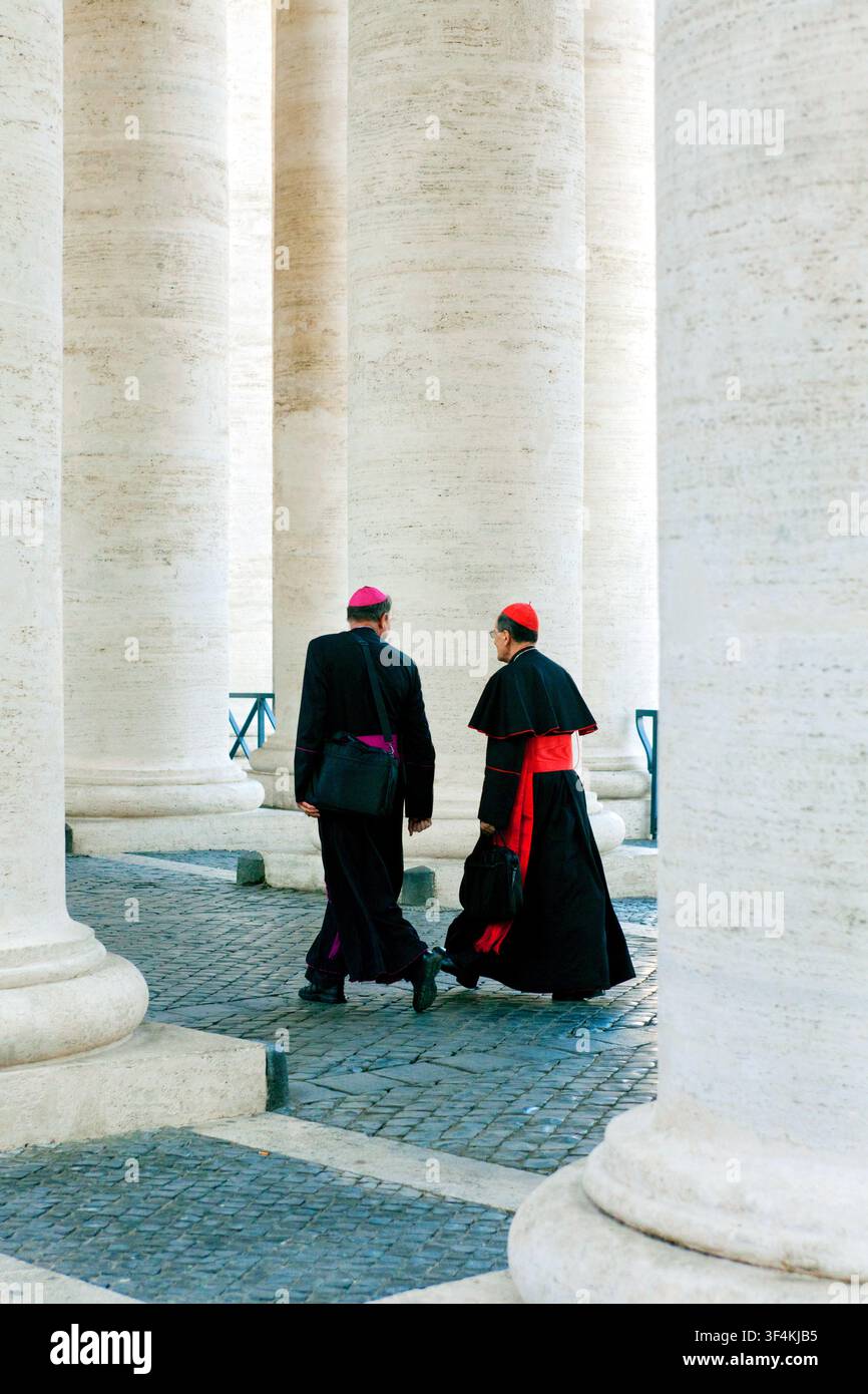 Ein Bischof und ein Kardinal in der Kolonnade, die zur St. Petersbasilika führt, Petersplatz / Piazza San Pietro, Vatikanstadt, Rom, Italien, Europa Stockfoto