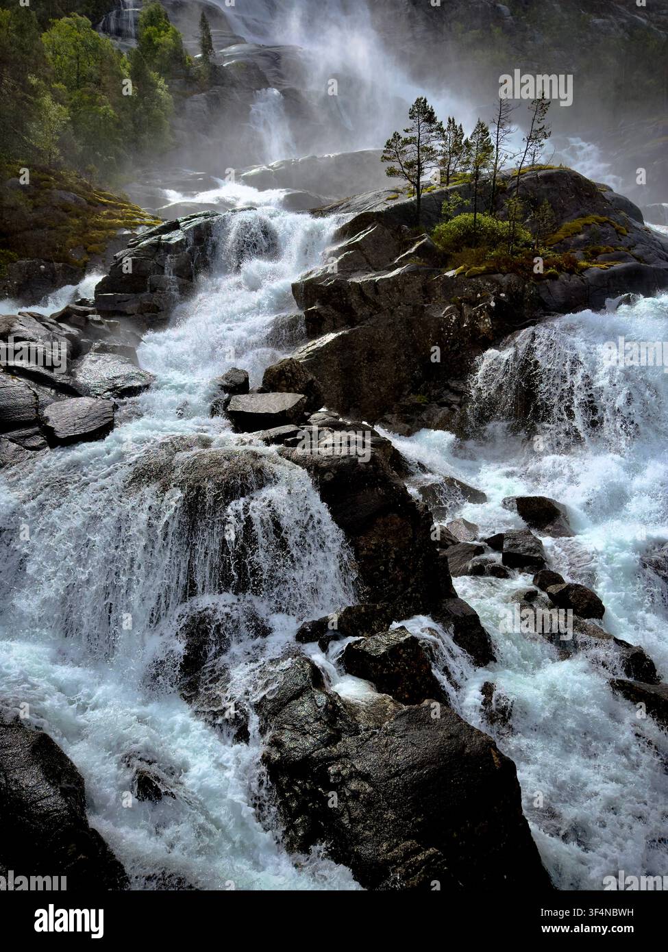 Dramatischer Nahaufnahme der tosenden Kaskaden und der sonnenbeschienenen Gischt am Langfossen-Wasserfall entlang des Åkrafjordens im Westen Norwegens. - Smartphone-aufgenommenes Stockfoto