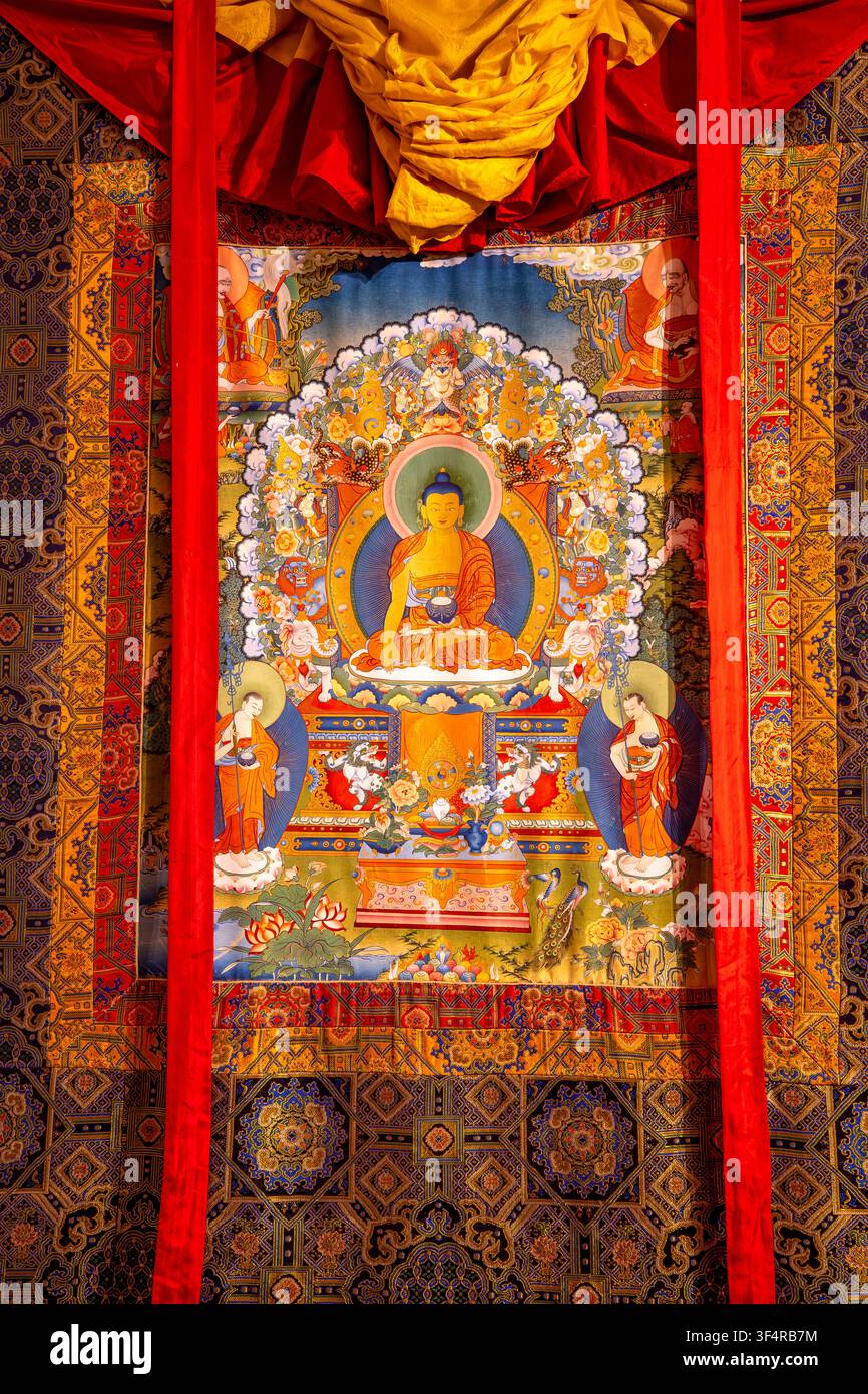 Norbulingka-Institut, Sidhpur, Himachal Pradesh, Indien. Ein Thangka-Gemälde, das Siddhartha Gautama in Meditation zeigt, umgeben von Nebenfiguren Stockfoto