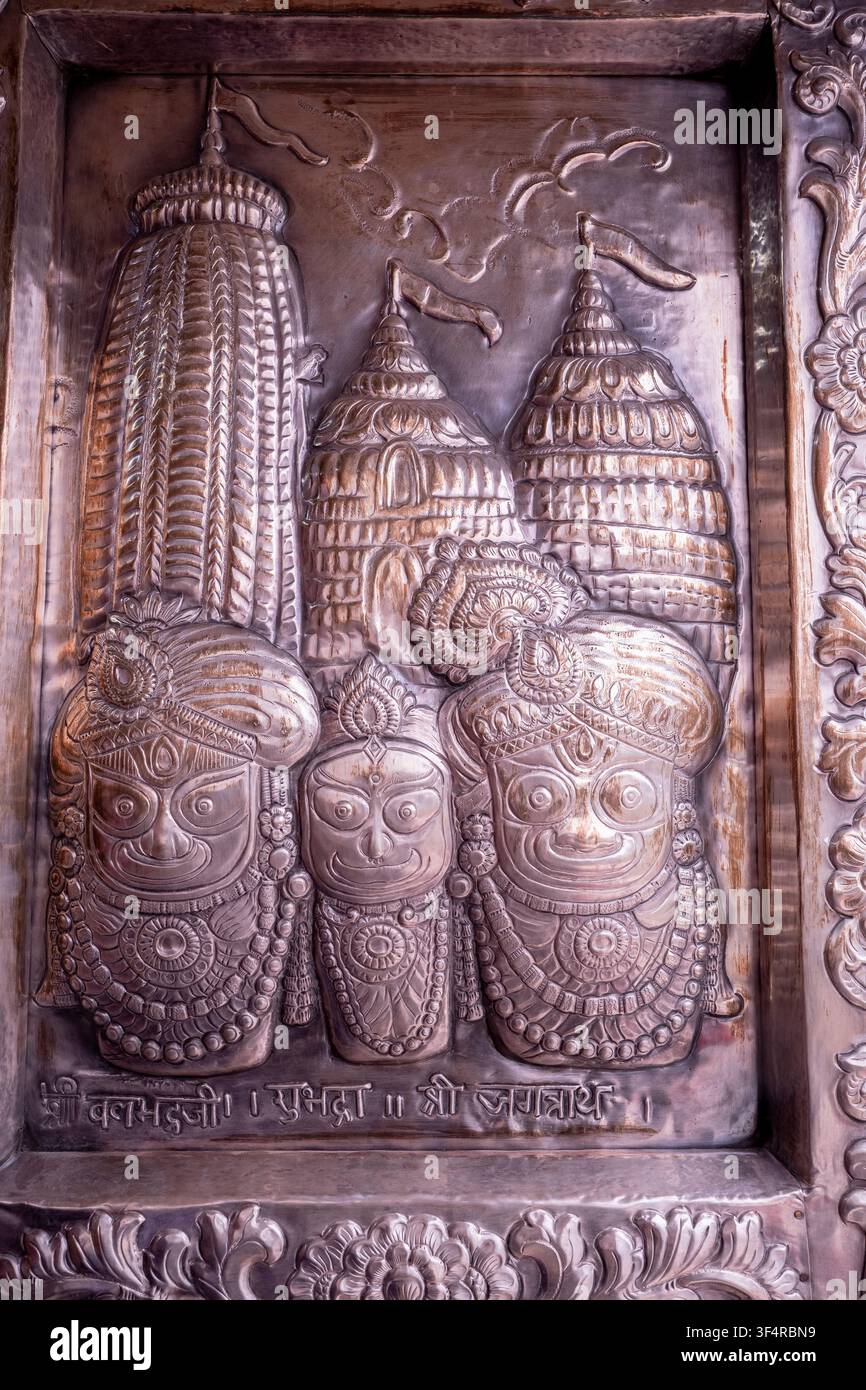 Metallskulptur, die die Gottheiten Balabhadra, Subhadra und Jagannath darstellt, mit architektonischen Darstellungen von Tempeln. Ornamentales Detail aus dem S Stockfoto