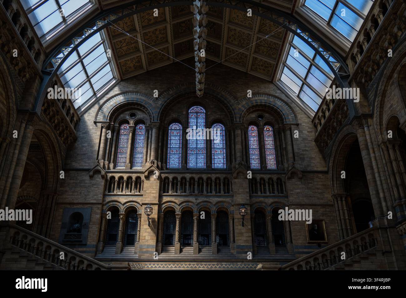 Architektonisches Innendetail des Naturhistorischen Museums mit Buntglasfenstern, Bögen und gewölbtem Dach in London, England. Stockfoto