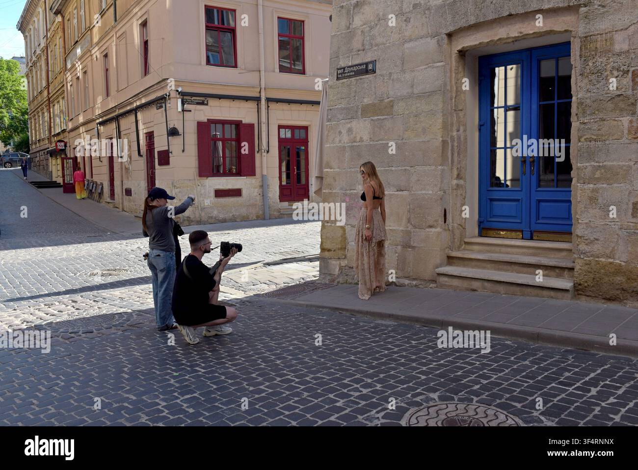 Mode-Fotoshooting vor einer Steinmauer im alten Viertel der Stadt Charkiw, Ostukraine, Mai 2026 Stockfoto