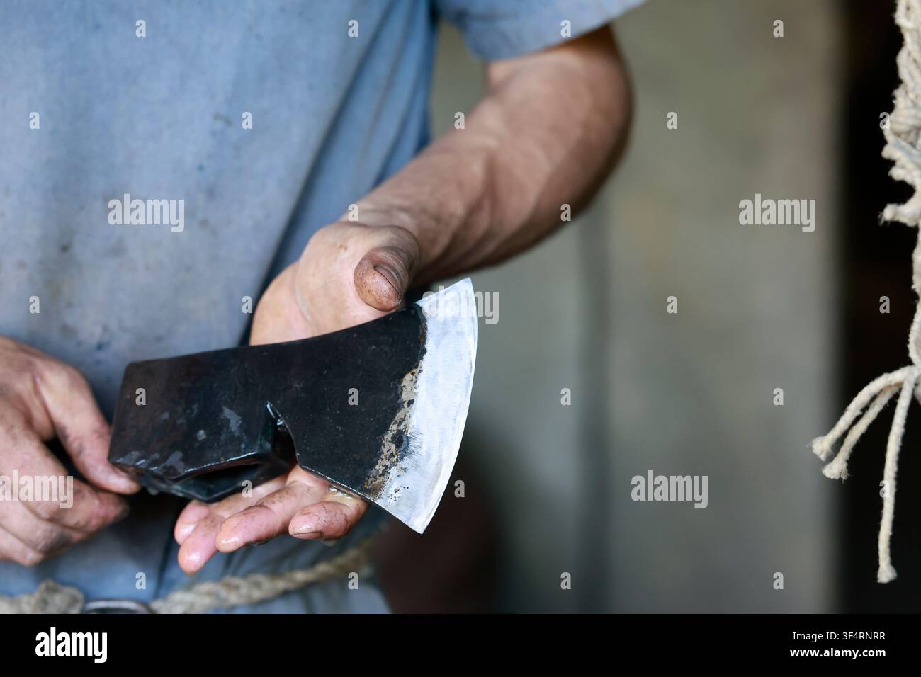 Ein Handwerker schwingt eine Stahlhacke, ein unverzichtbares Werkzeug für den Bau des Château de Guédelon. Diese mittelalterliche Baustelle setzt traditionelle Stockfoto
