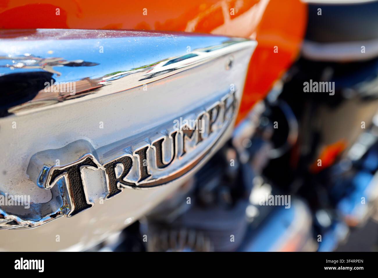 Ein schwarz-weißes verchromtes Triumph-Emblem auf dem Tank eines Oldtimermotorrads. Stockfoto