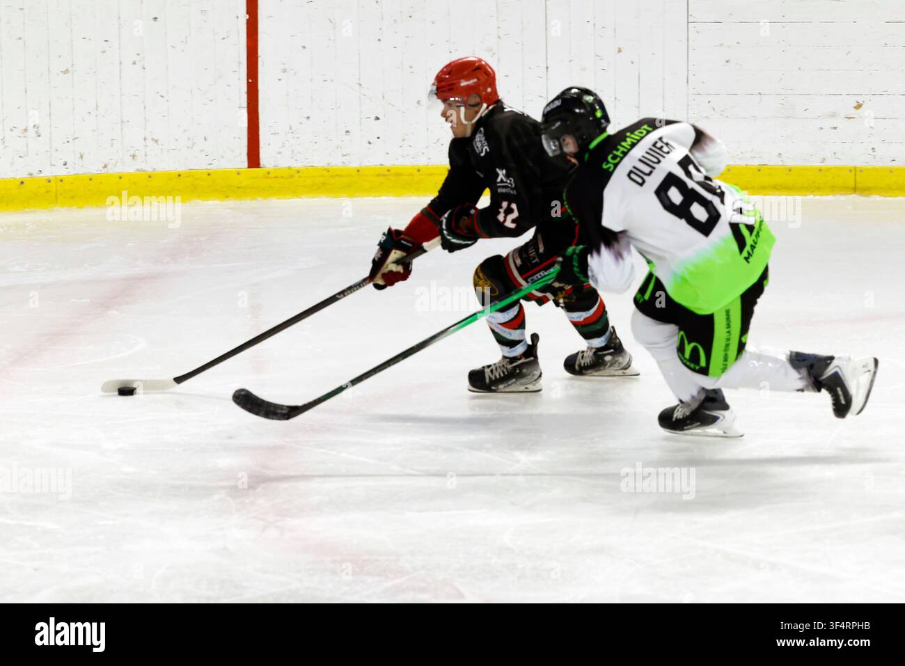 Zwei Eishockeyspieler jagen den Puck während eines intensiven Spiels. Stockfoto
