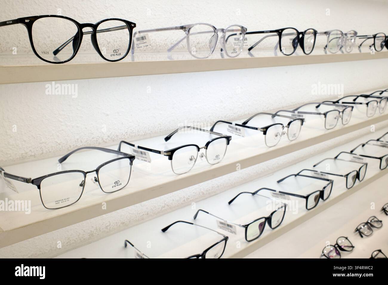 Eine vielfältige Auswahl an modernen und trendigen Brillenfassern wird in einem Optikergeschäft auf Regalen präsentiert. Ho-Chi-Minh-Stadt, Vietnam. Stockfoto