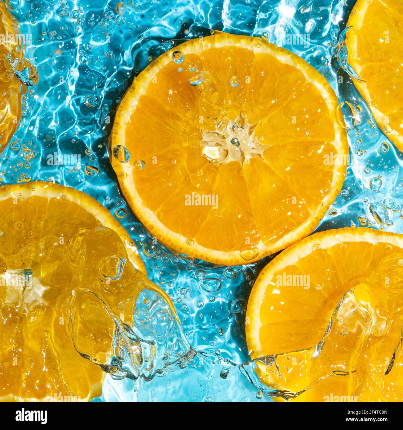 Abstrakter orangefarbener Hintergrund, Obst in spritzendem Wasser. Stockfoto