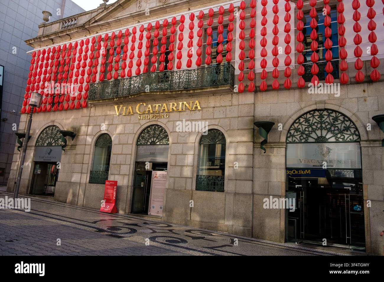 Porto, 11. Juni 2022: Via Catarina-Einkaufsgebäude mit einer modernen Kunstinstallation aus roten Laternen, die seine Steinfassade schmückt. Stockfoto
