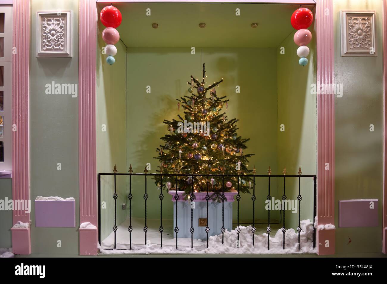 Weihnachtsbaum, der mit bunten Neon-Lichterketten, Kugeln und anderem Spielzeug in der Nacht auf der Straße geschmückt ist. Weihnachts- und Neujahrsfeiertage Stockfoto