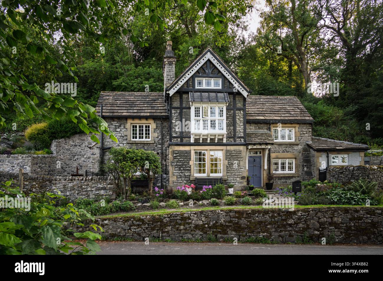 Das historische Dale-End-Cottage zeigt einzigartige Holzverkleidung und zeitgenössische Merkmale vor einer Waldkulisse in Bradwell, Peak District, England Stockfoto