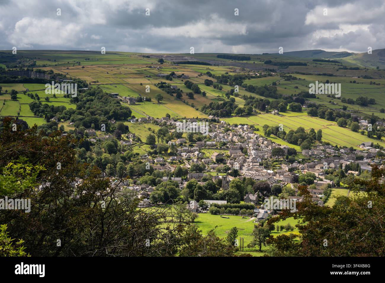 Eine weitläufige Hochwinkelaufnahme vom Bradwell Edge Summit zeigt das historische Dorf, das sich zwischen auffälligen Flickfeldern und sanften grünen Hügeln erstreckt Stockfoto