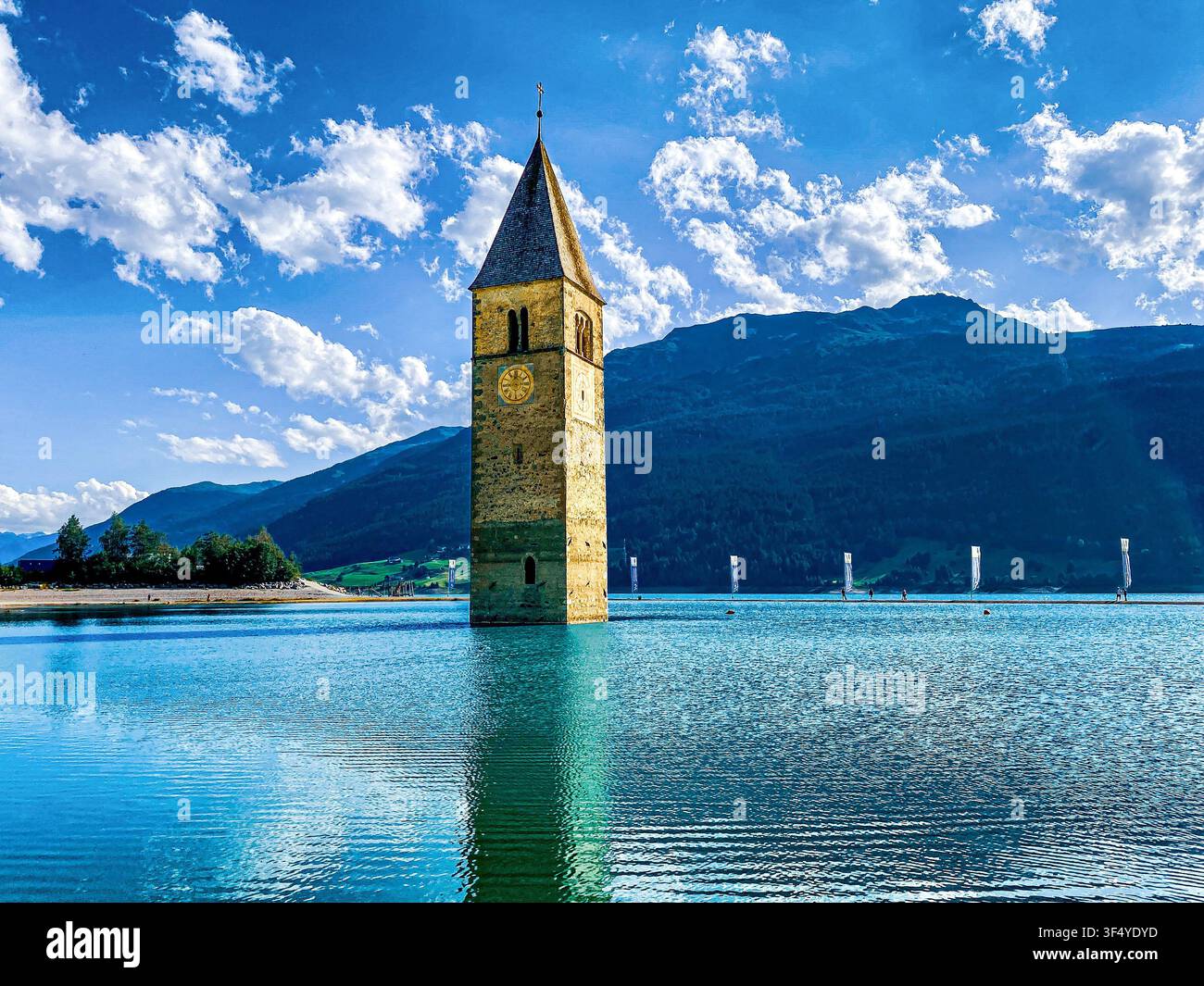 Historischer untergegangener Glockenturm der Kirche St. Katharina, der aus dem türkisfarbenen Wasser des Reschensees in Südtirol, Italien, aufsteigt Stockfoto