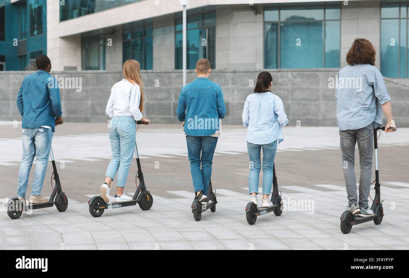 Gruppe von jungen Erwachsenen, die Elektroroller in einer städtischen Umgebung fahren, nicht zu erkennen, Lebensstilkonzept Stockfoto