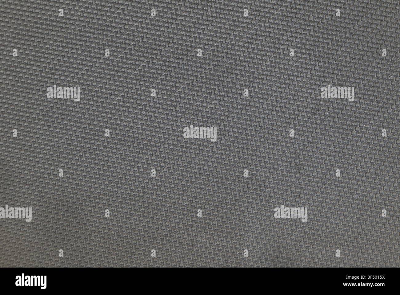 Graues Textil mit einem detaillierten gewebten Muster und einer strukturierten Oberfläche Stockfoto