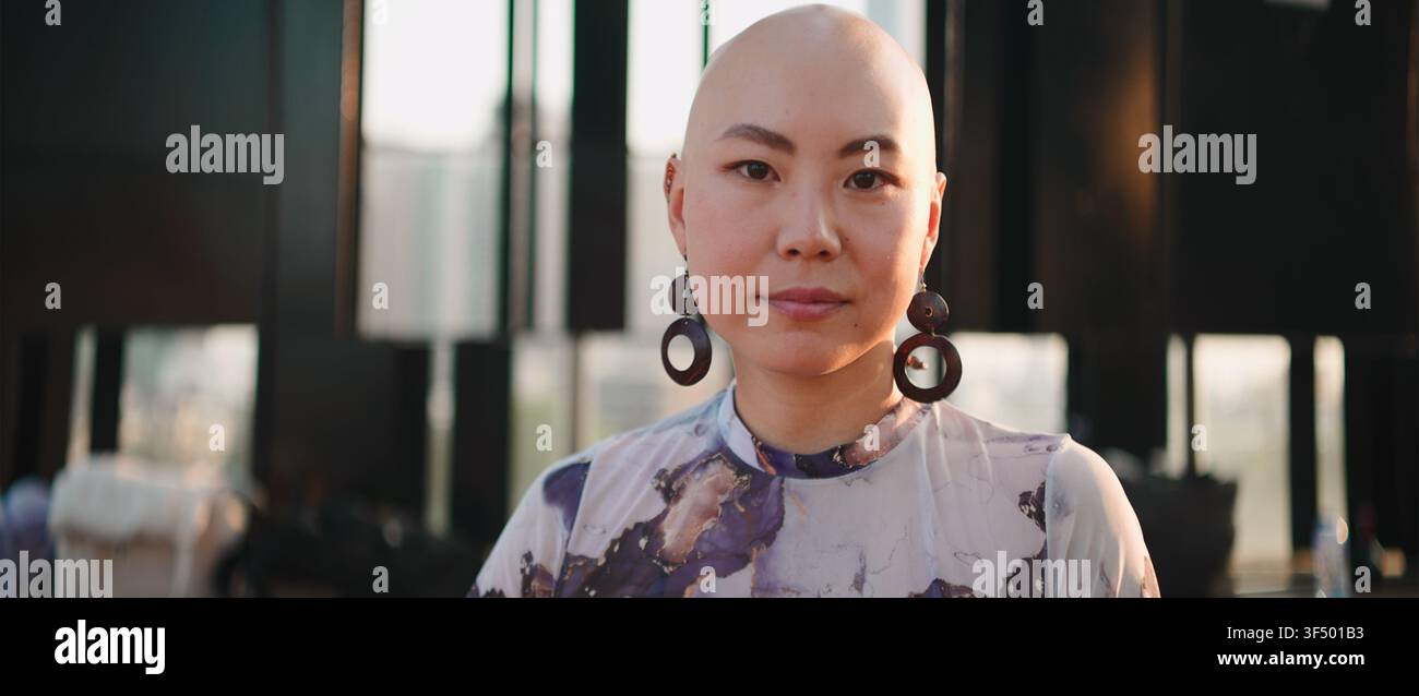 Asiatische Frau mit kurzen Haaren schaut in die Kamera und drückt Selbstvertrauen und moderne Identität aus Stockfoto
