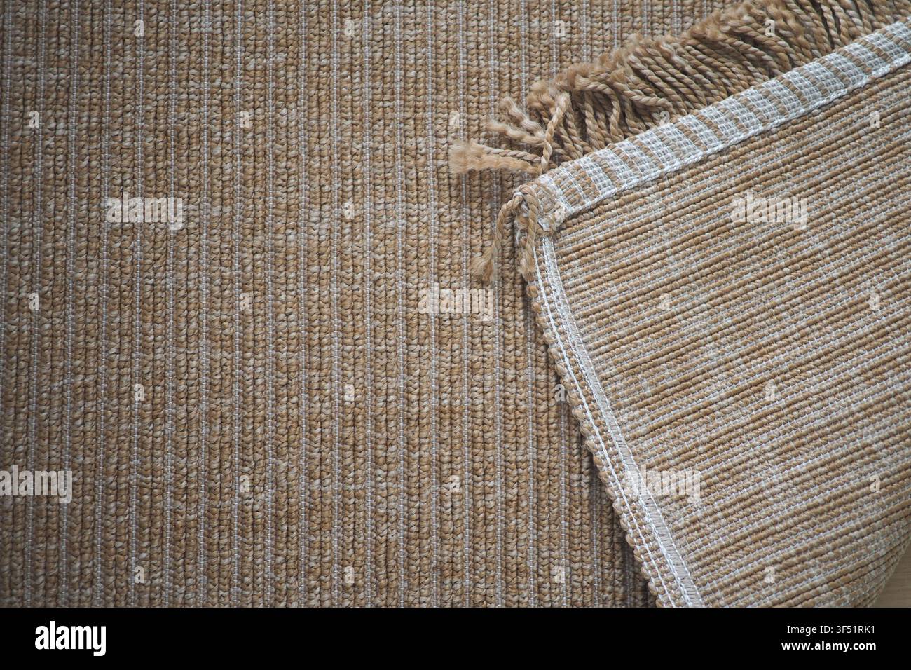 Gewebter Teppich, der während des Tageslichts auf einem strukturierten Boden platziert ist Stockfoto