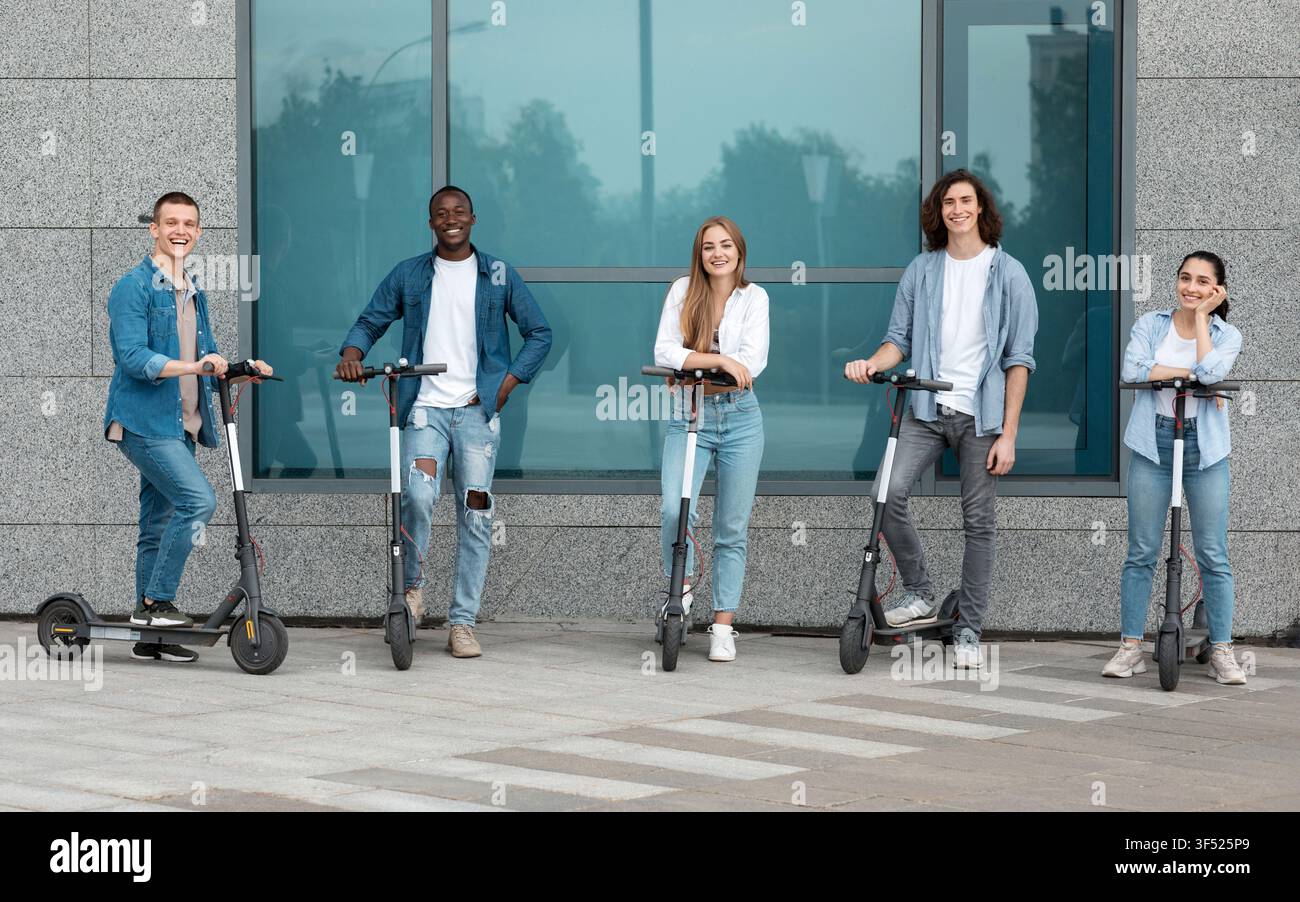 Gruppe von jungen Erwachsenen fährt Elektroscooter in einer städtischen Umgebung, glücklich und entspannt Stockfoto