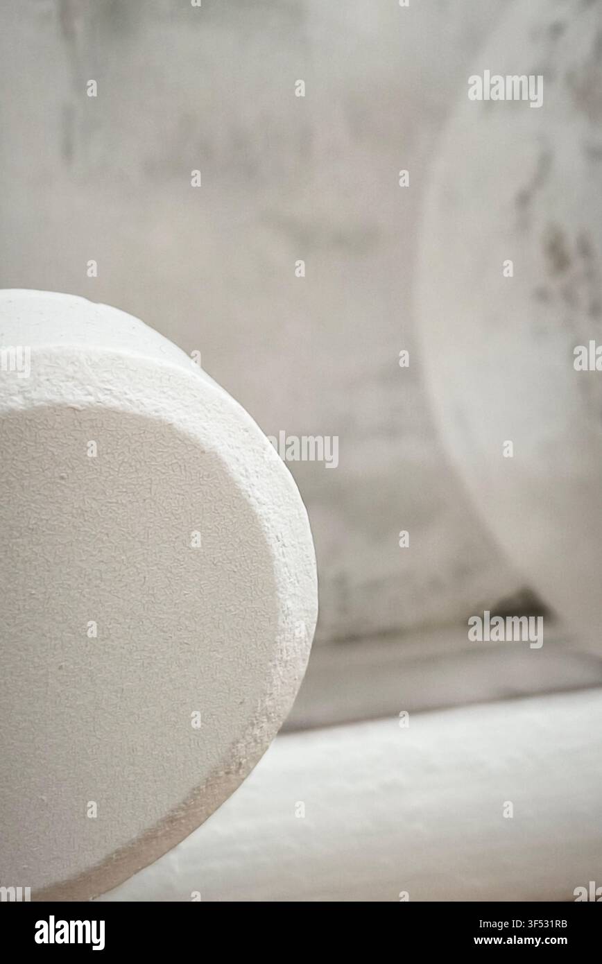 Minimalistischer abstrakter Hintergrund mit weißen geometrischen Betonformen und strukturierter Putzoberfläche - Smartphone-aufgenommenes Stockfoto