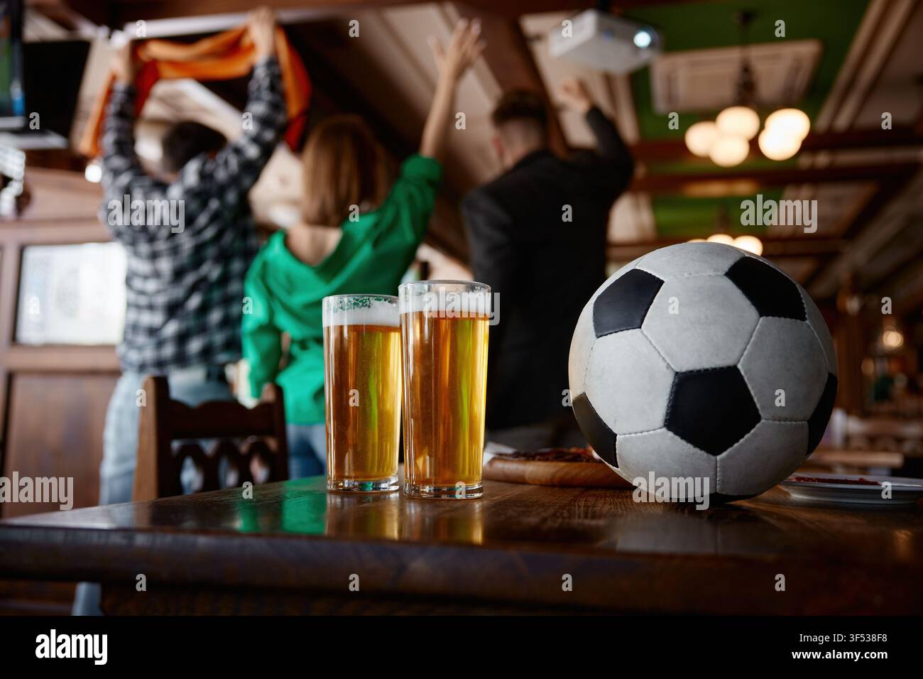 Festliche Umgebung mit Getränken und Ball. Bereit für das Spiel mit Getränken und lebhafter Atmosphäre Stockfoto