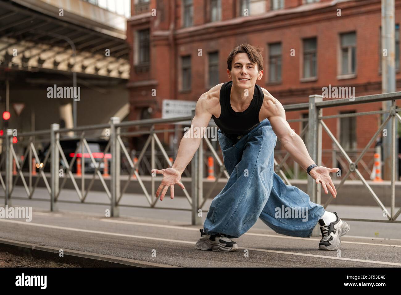 Junger Mann in weiten Jeans tanzt auf einer Stadtstraße Stockfoto