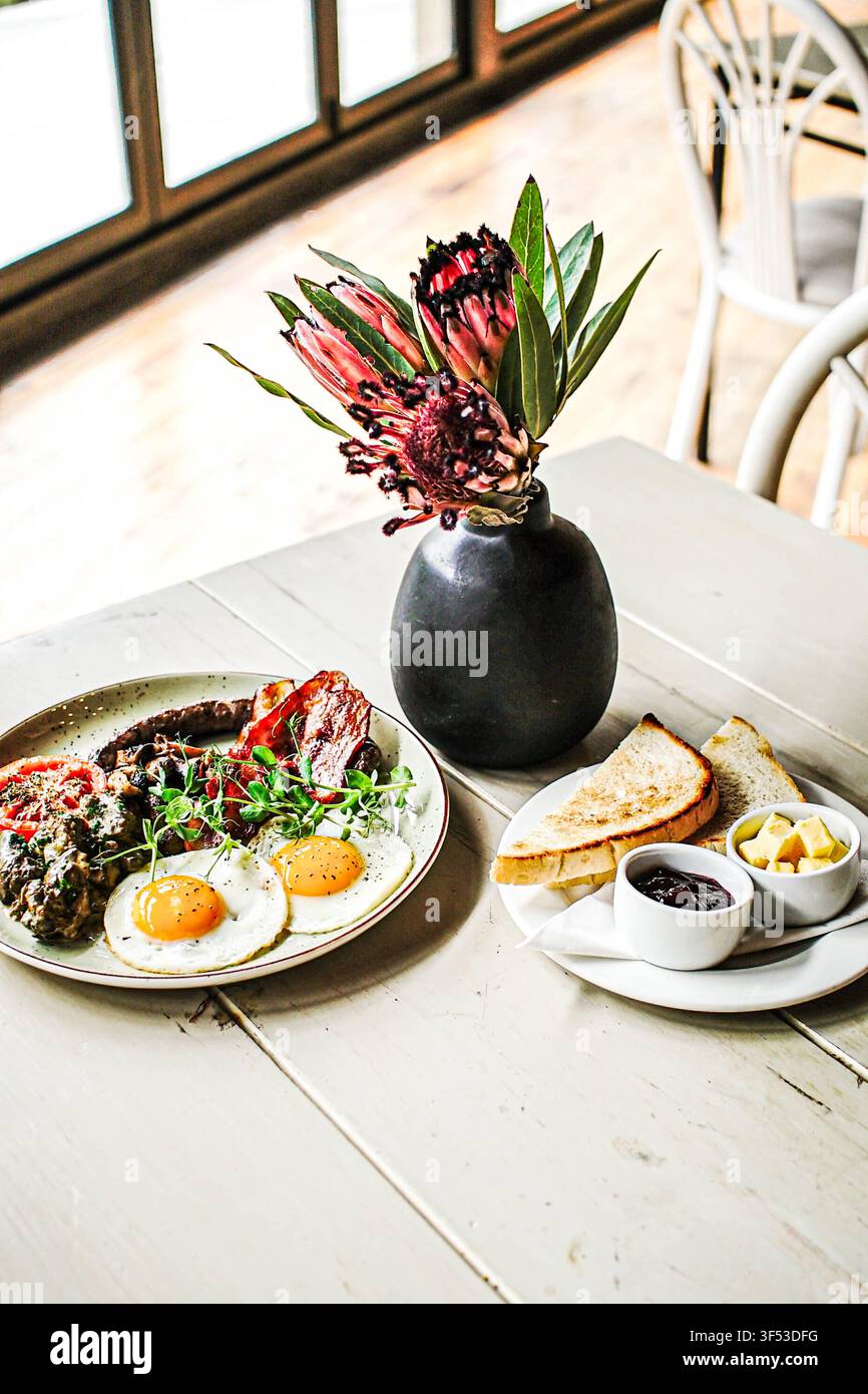 Herzhaftes Frühstück mit Protea-Blumen auf dem Tisch Stockfoto