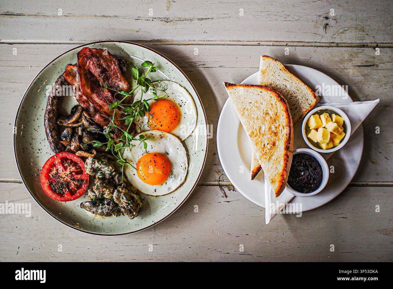 Herzhaftes gekochtes Frühstück auf einem rustikalen Tisch Stockfoto
