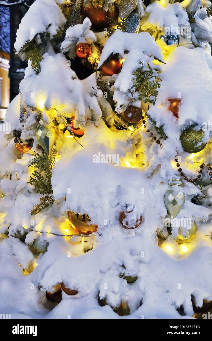 Weihnachtsbaum, der mit bunten Neon-Lichterketten in der Nacht auf der Straße geschmückt ist. Weihnachts- und Neujahrsfeiertage Stockfoto