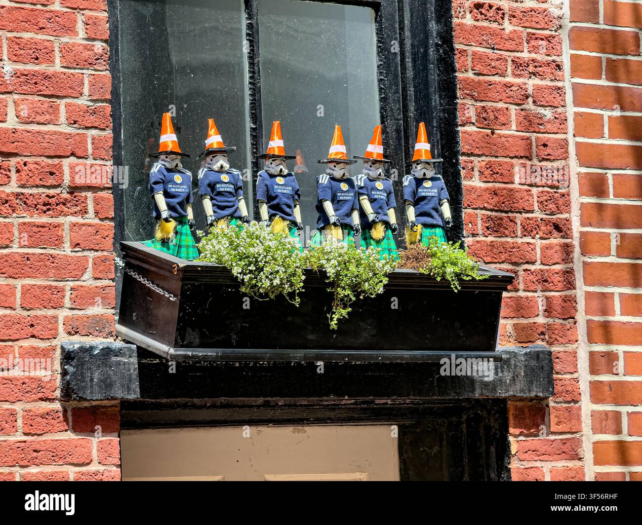 Stormtrooper-Statuen, die von schottischen Fußballfans, bekannt als die Tartan Army, mit orangefarbenen Verkehrskegeln und Kilts geschmückt wurden, während der "Coning of Boston"-Zug Stockfoto