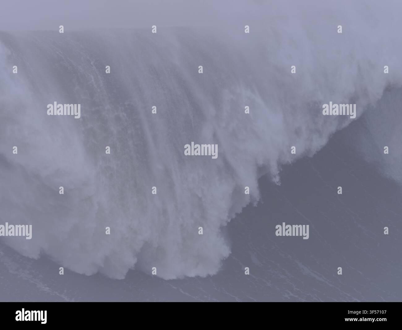 Eine massive Meereswelle, die während turbulenten und bewölkten Wetters mit Gischt und Spritzwasser kreuzt und bricht Stockfoto