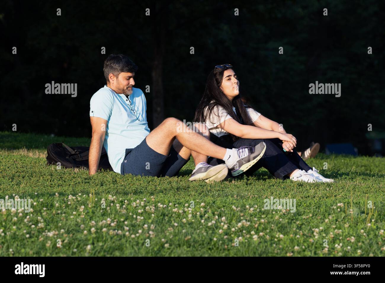 Ein junges Paar sitzt zusammen auf dem Rasen im Boston Common, Boston, Massachusetts. Stockfoto