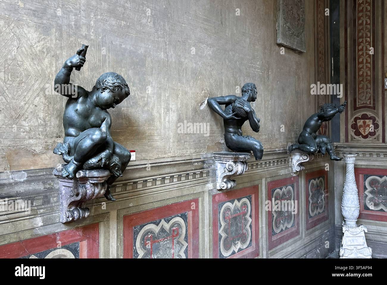 Florenz, Italien - Mai 2026: Renaissance-Bronze-Putti-Skulpturen auf Wandkonsolen im Bargello-Nationalmuseum Stockfoto