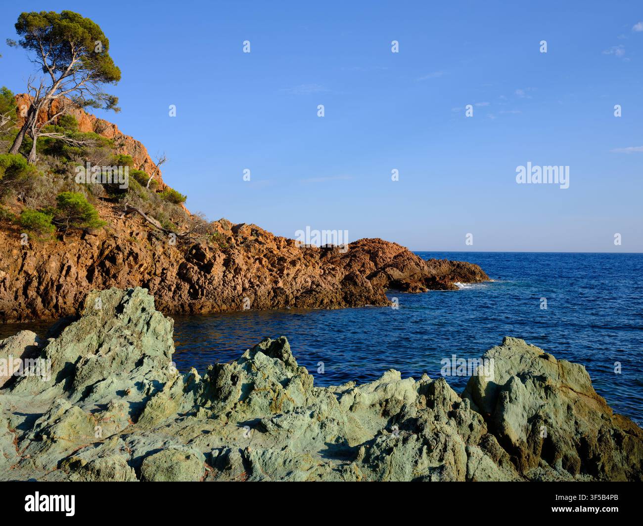 Das Esterel-Massiv ist bekannt für seine roten Felsen, die sich vom Blau des Mittelmeers abheben. Am Cap du Dramont fügen einige grüne Felsen zur Palette hinzu. Stockfoto