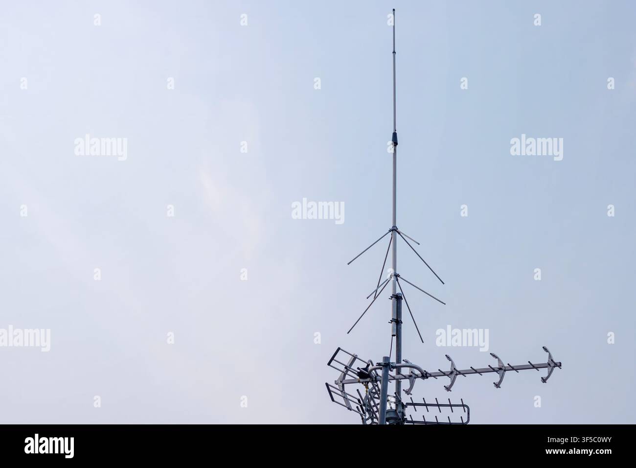 Fernsehantenne und Telekommunikationsempfangsmast vor einem klaren Tageshimmel montiert. Hochwertiges Foto Stockfoto
