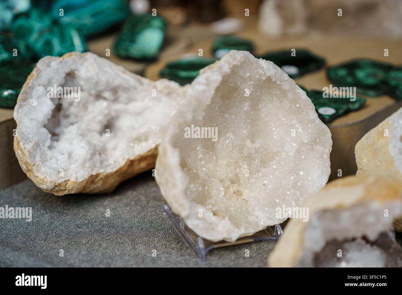 Funkelnde weiße Quarzgeoden und grüne Malachit-Mineralproben. Kristalle- und Edelsteinsammlung, Geowissenschaftsforschung, Heilsteine, Gesteinstextur im geologischen Museum Stockfoto