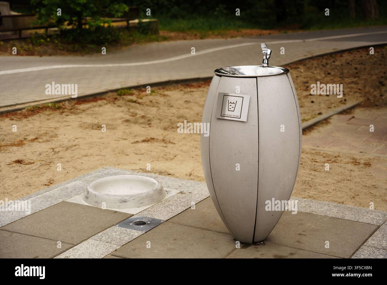 Moderne und minimalistische elliptische Beton-Trinkwasserfontäne in einem Park, städtische öffentliche Einrichtungen, nachhaltige Parkinfrastruktur, modernes kommunales Design, Trinkwasserstation Stockfoto