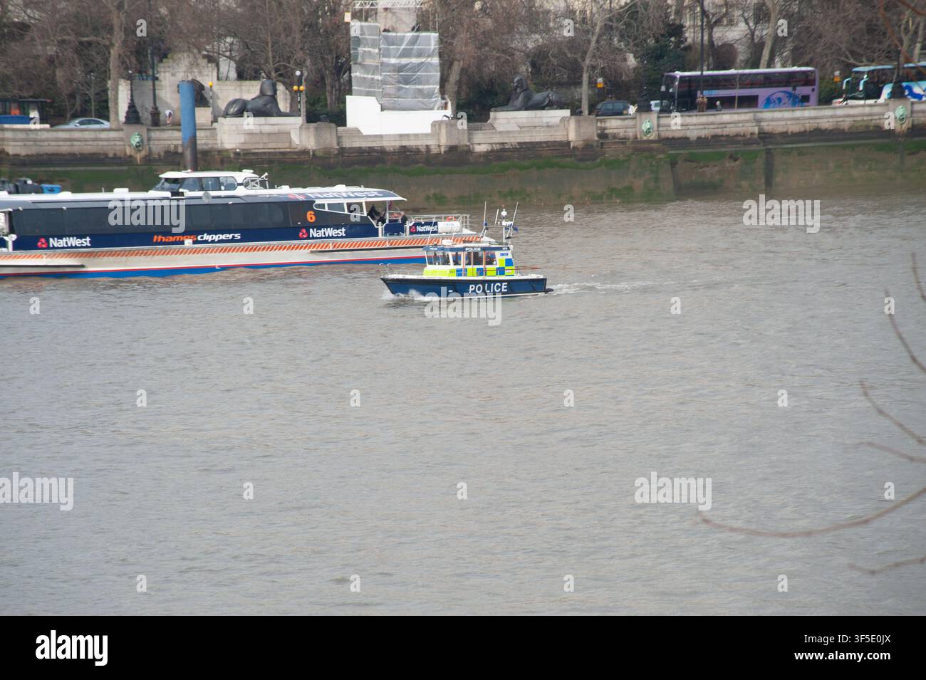 London, UK. 13. Januar 2009. Ein Boot der Metropolitan Police patrouilliert auf der Themse neben einer von NatWest gebrandeten Thames Clippers-Passagierfähre. Im Hintergrund sind die Sphinx-Statuen zu sehen, die die Kleopatra-Nadel-Obelisk auf der Victoria Embankment umrahmen, umgeben von provisorischen Gerüsten während der Bauarbeiten im Winter. Stockfoto