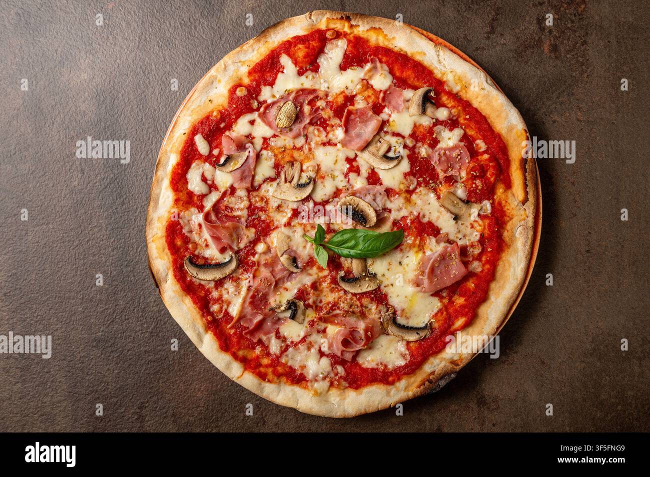 Traditionelle italienische Capricciosa-Pizza mit Tomatensauce, Mozzarellakäse, gekochtem Schinken, Pilzen und pikanter Salami, von oben fotografiert Stockfoto