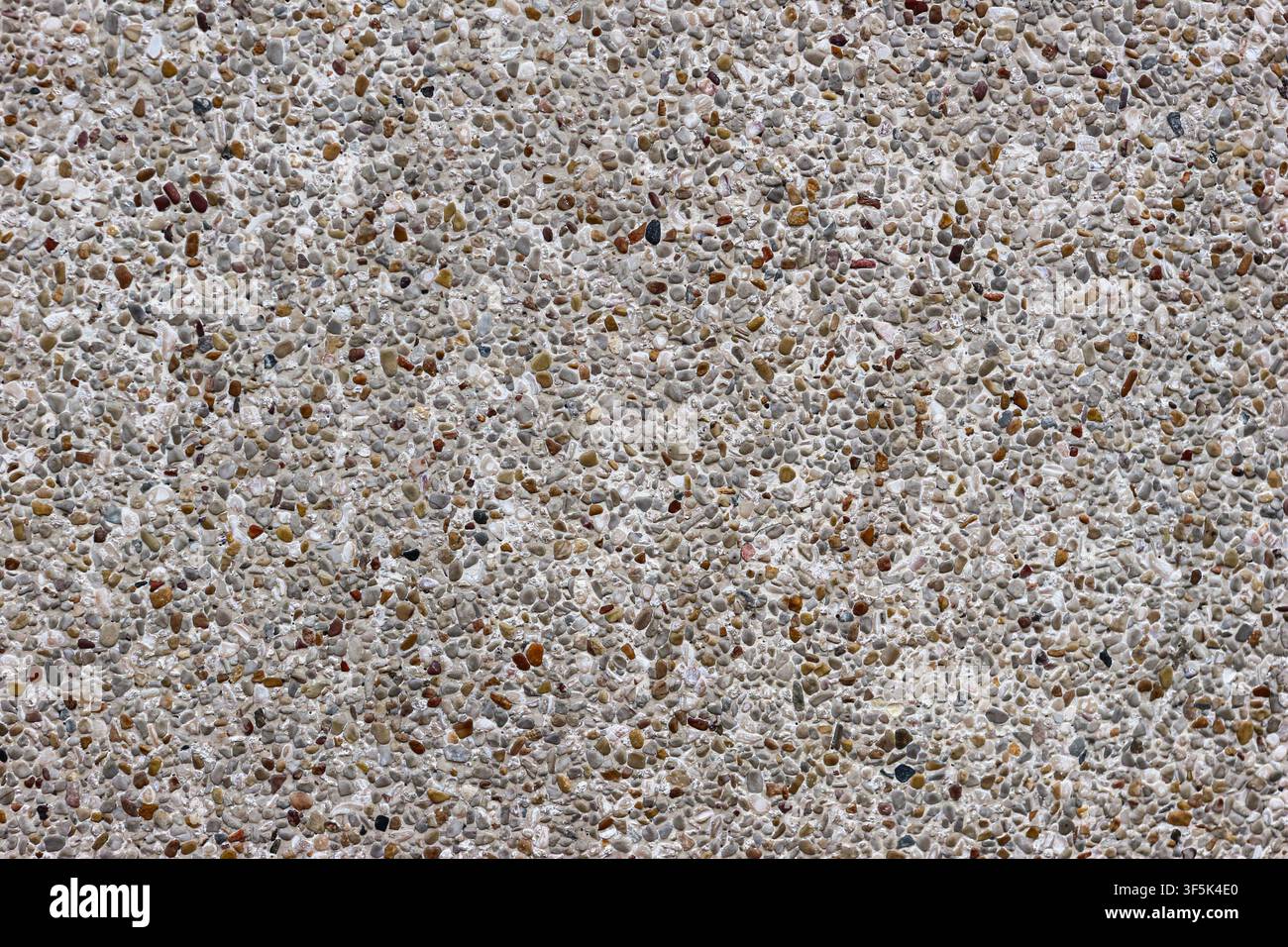 Außenwand aus Terrazzo mit feinem Kiesgranulat, das in Zement eingebettet ist, und zeigt eine langlebige architektonische Textur und natürliche Materialdetails. Stockfoto