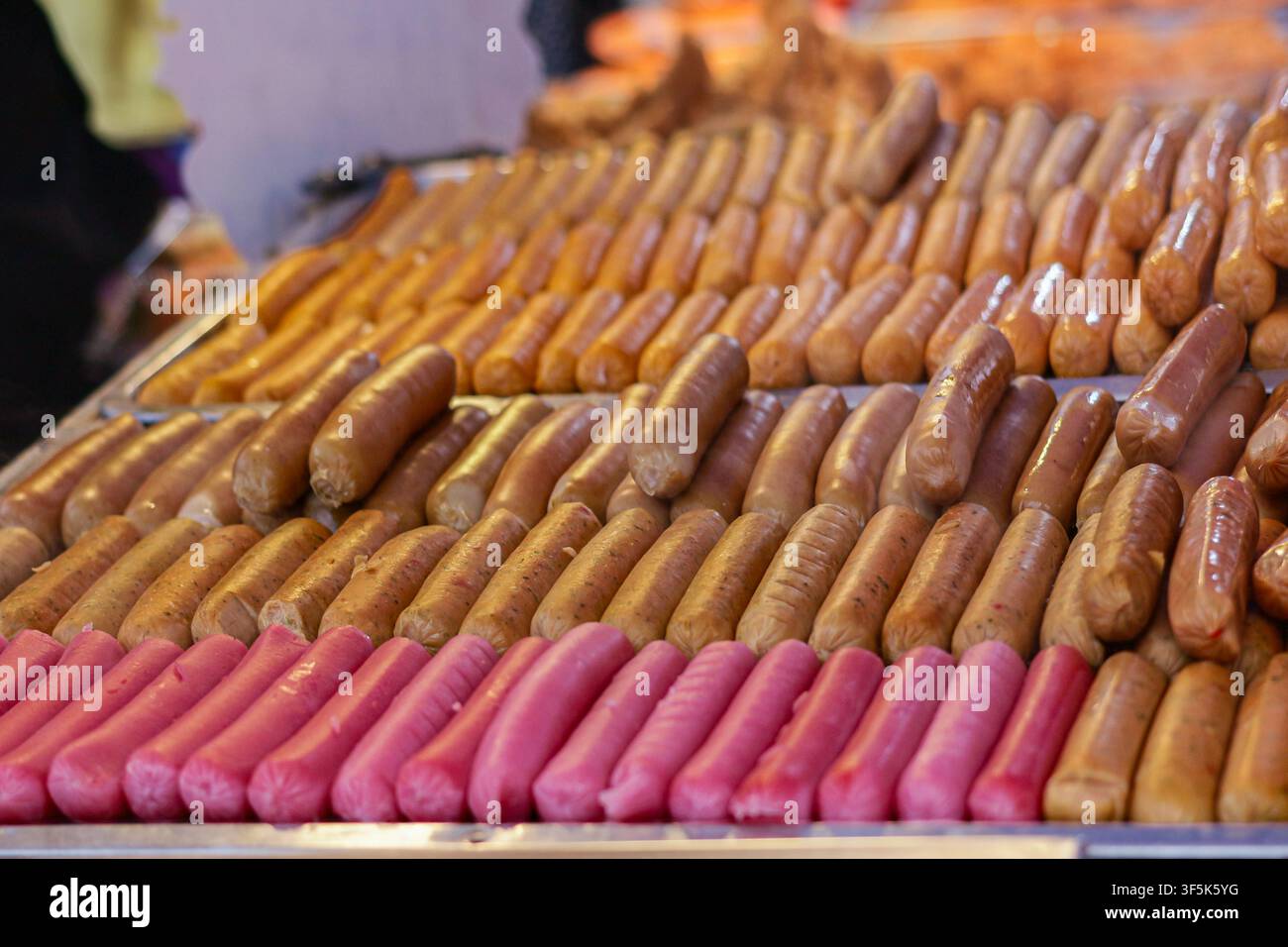 Verschiedene gegrillte Würste, die auf einem Grill auf einem thailändischen Nachtmarkt präsentiert werden, geeignet für die redaktionelle Nutzung von asiatischem Straßenfood und Reisekultur. Stockfoto