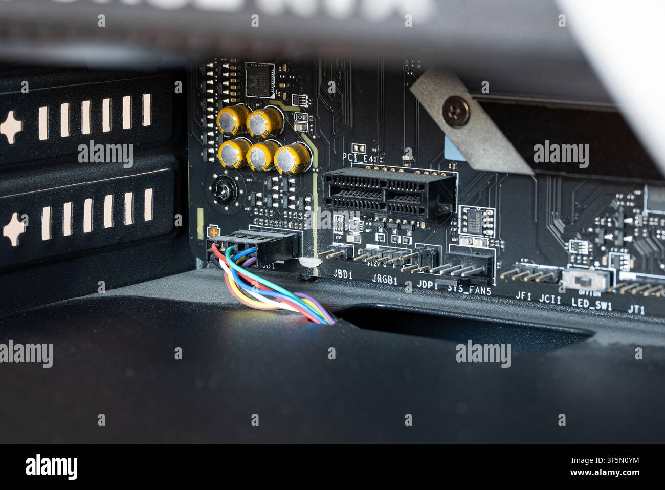Urdorf, Schweiz, 29. Juli 2026. Detaillierte Ansicht von Motherboard-Headern, Audiokondensatoren, Frontpanel-Audiokabel und PCIe-Erweiterungsslot unter einem i Stockfoto