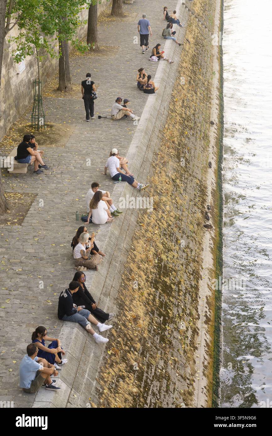 Menschen, die sich entlang des Steinquais der Seine in Paris, Frankreich, entspannen. Stockfoto