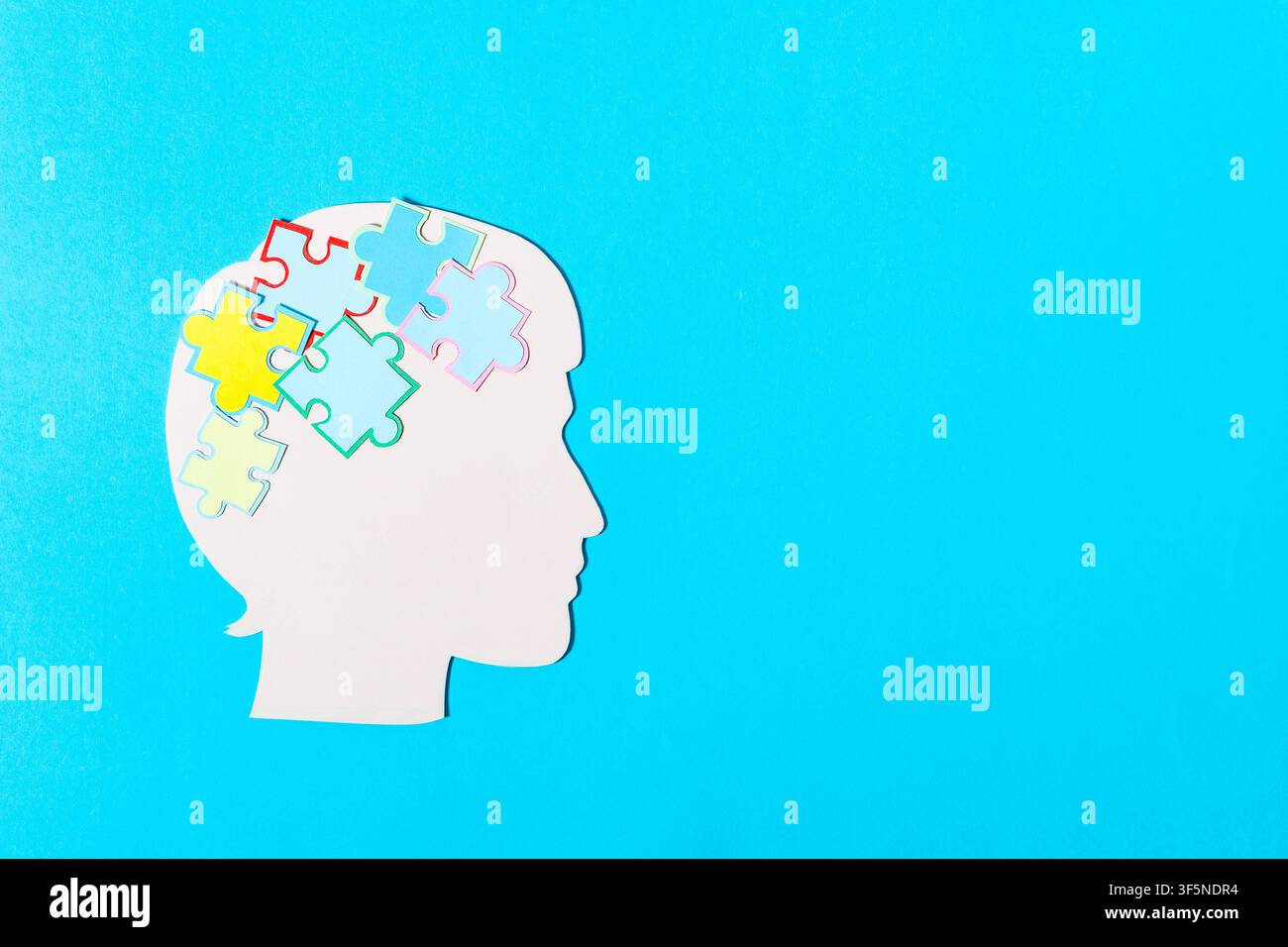 Papier-Schnitt-Kunstkonzept mit einem menschlichen Profil und Puzzle-Teilen, die psychische Gesundheit symbolisieren. Stockfoto
