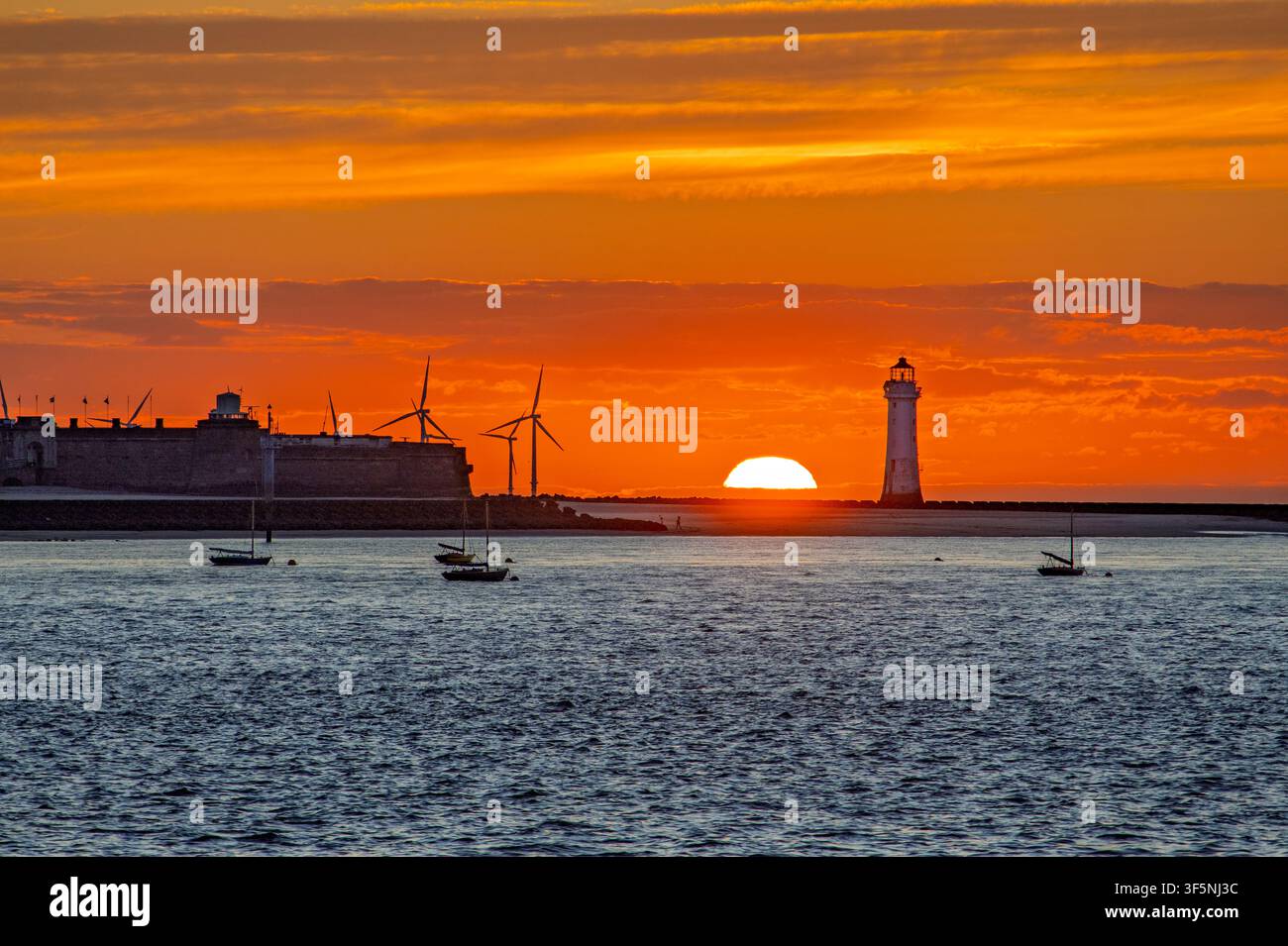 New Brighton Perch Rock Leuchtturm vor einer hellroten untergehenden Sonne an der Mersey Stockfoto