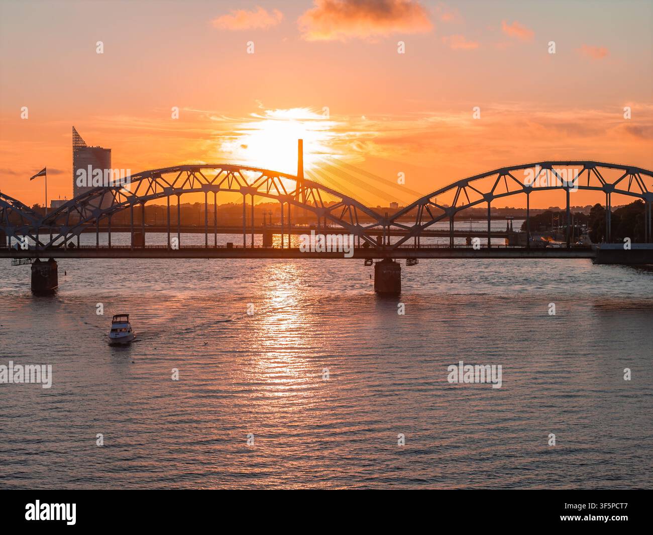 Stahl-Eisenbahnbrücke über die Daugava in Riga bei Sonnenuntergang Stockfoto