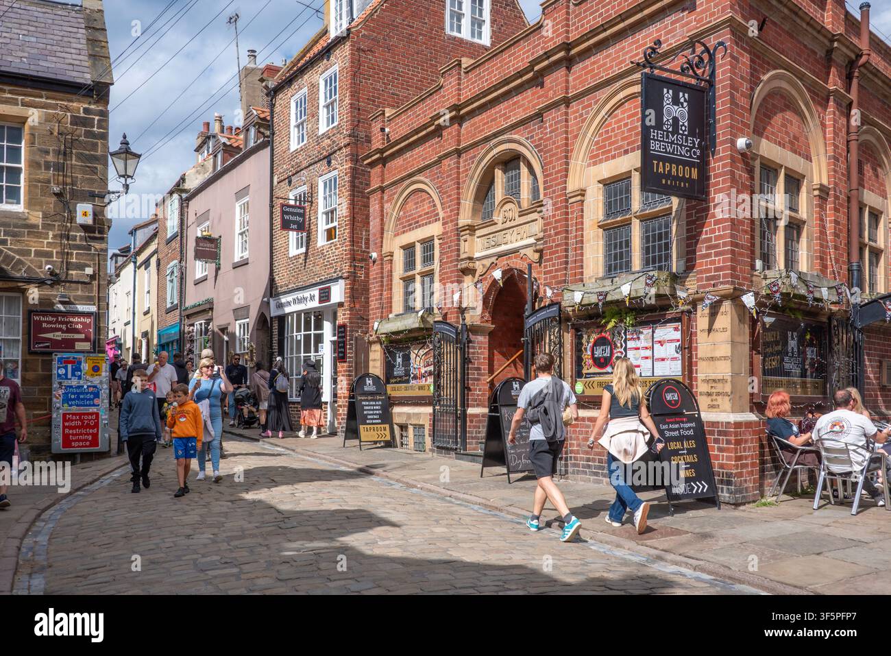 Besucher genießen die Geschäfte in der Church Street, Whitby, North Yorkshire Stockfoto