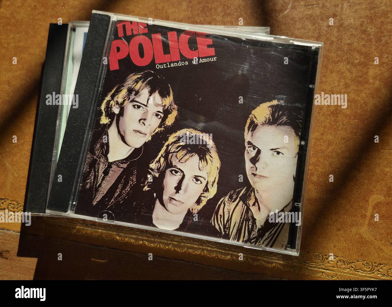 The Police - Outlandos d'Amour Debüt-Studioalbum Compact Disc Jewel Case auf einer strukturierten Holzoberfläche - Smartphone-aufgenommenes Stockfoto