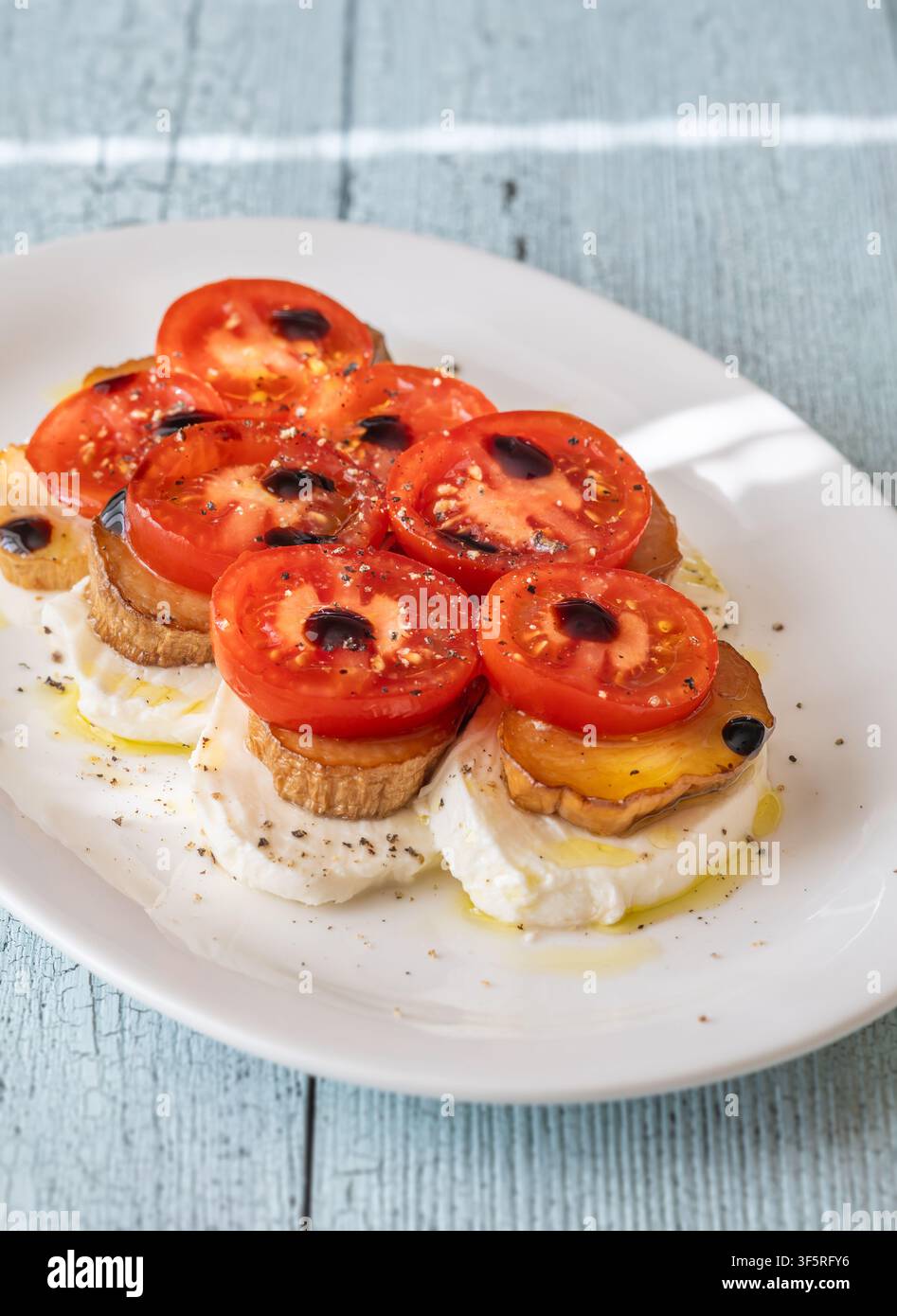 Frischer italienisch inspirierter Vorspeise, der Mozzarella, Tomaten, Pilze, Balsamico-Glasur und aromatisches Olivenöl wunderschön kombiniert. Stockfoto