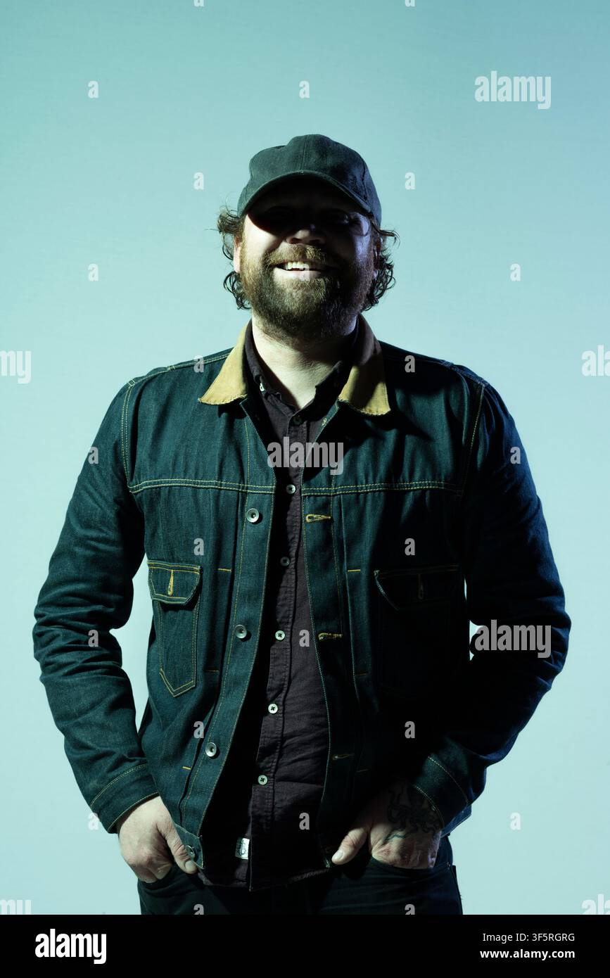 Porträt von Scott Hutchison, Sänger von Frightened Rabbit. Er trägt eine Jeansjacke und einen Baseballcap Stockfoto