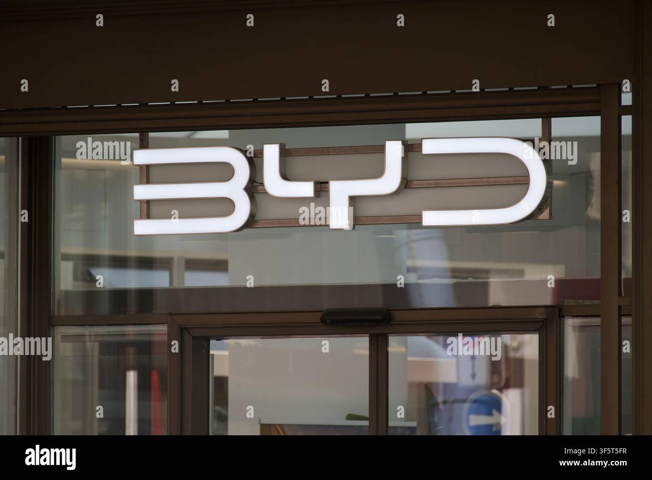 Zürich, Schweiz - 30. Juli 2026: BYD-beleuchtetes Firmenlogo-Schild Nahaufnahme, montiert auf der modernen Glas-Eingangsfassade eines Autohandels Stockfoto